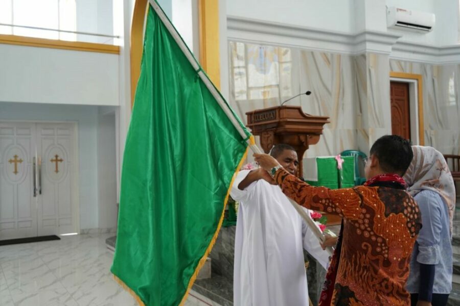 Pejabat Bupati Maluku Tengah Dr. Muhamat Marasabessy, Menyerahkan Bendera Pataka Pesparani Katolik Malteng Ke Pastor Paroki Masohi