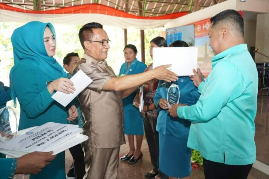 Pejabat Bupati Maluku Tengah DR. Muhamat Marasabessy, Didampingi Ketua PKK Ny. Bella Marasabessy, Menyerahkan Hadia Kepada Tim PKK Kecamatan Pemenang Lomba (1)